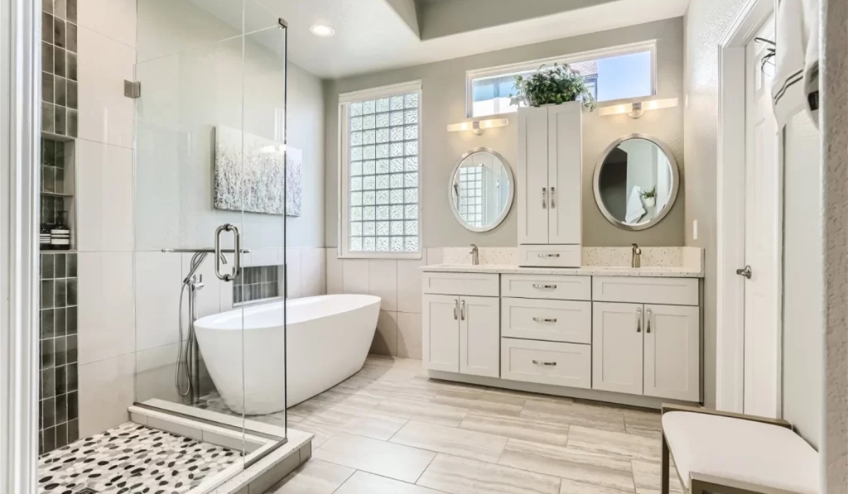Traditional bathroom design in Auburn, CA with pedestal sink, hex tile flooring, wall sconces, and vintage-style mirror.