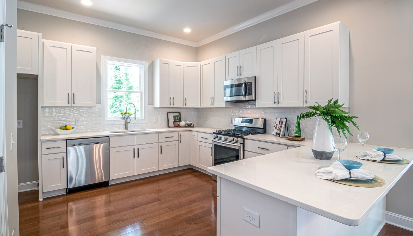 Elegant classic kitchen remodel in Citrus Heights, CA featuring white shaker cabinets, quartz countertops, subway tile backsplash, and pendant lighting.