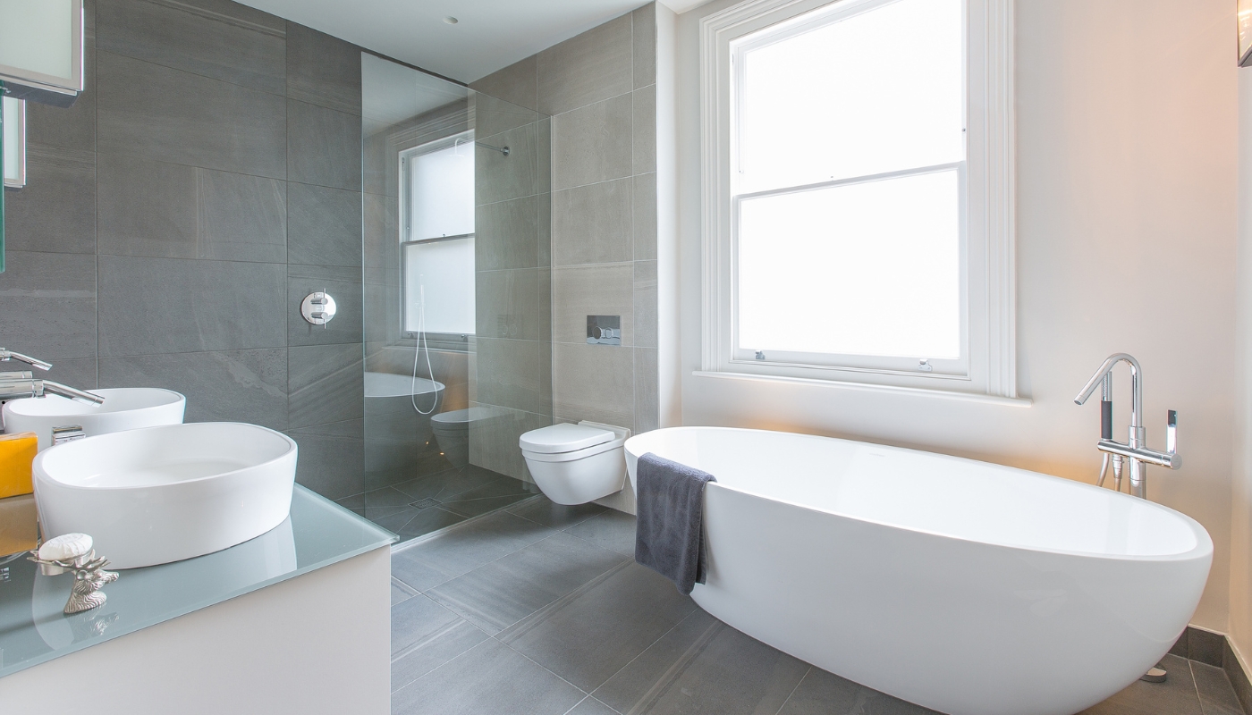Elegant classic bathroom remodel in Roseville, CA featuring marble countertops, freestanding bathtub, and chrome fixtures by Remodel California.